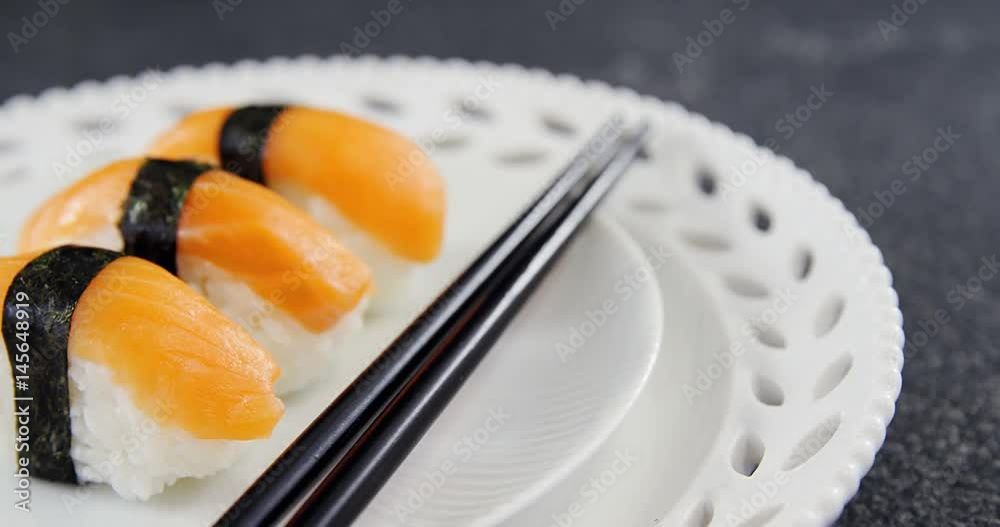 Sushi served on plate with chopsticks Sushi served on plate with chopsticks