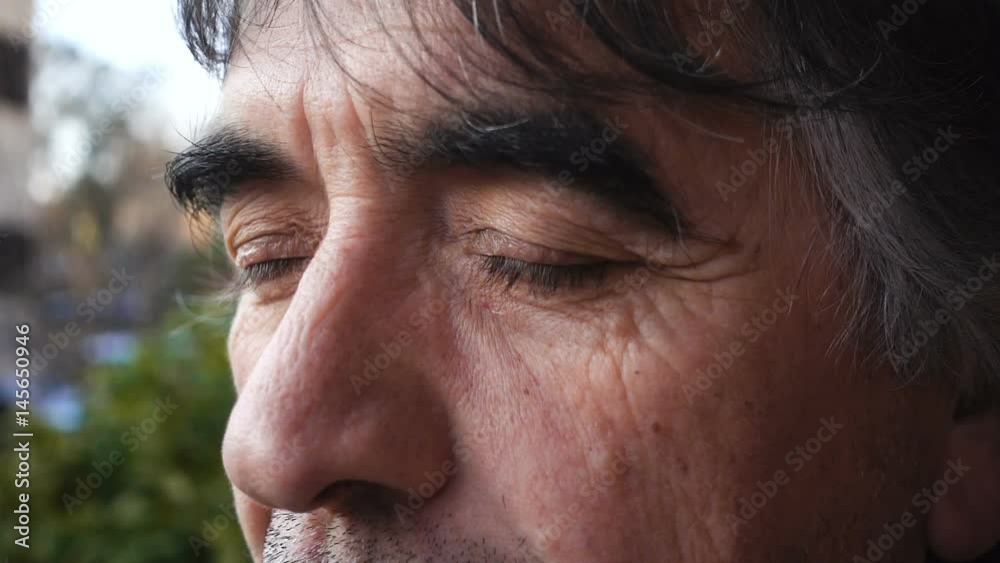 Thoughtful mature man opens his eyes,slow motion
