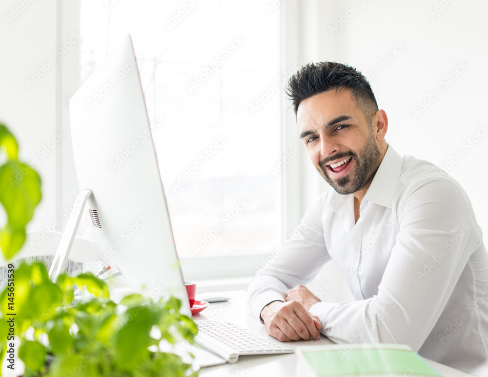 Young businessman working at office on computer desk