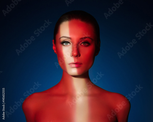 Fashion art portrait of elegant naked young woman with color light on her face