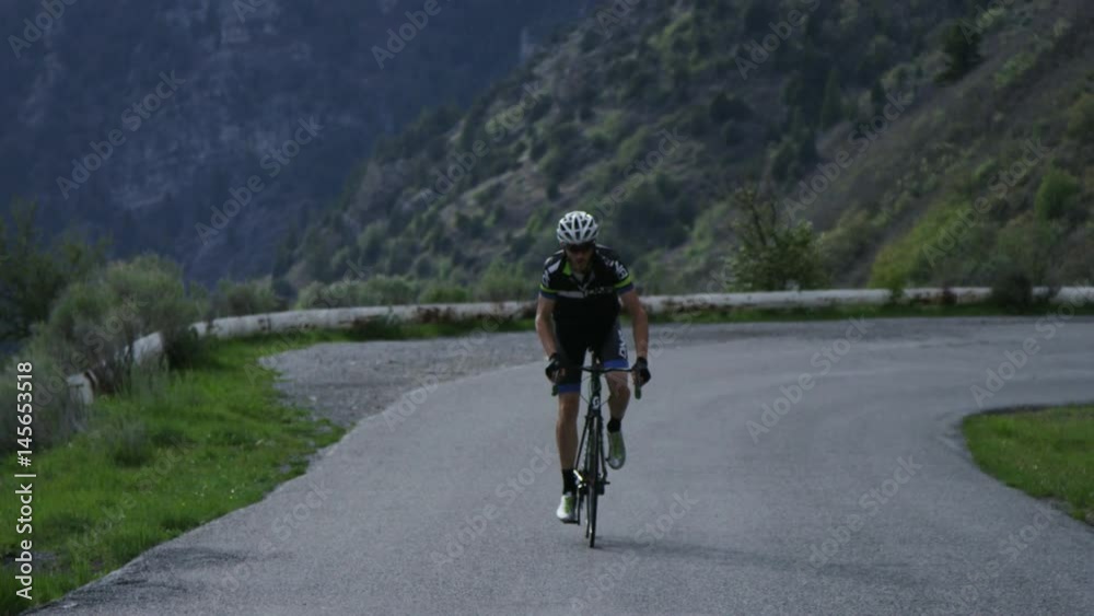 Man road biking through mountains Man road biking through mountains