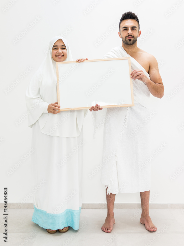 Muslim man posing as ready for Hajj visiting Kaaba in Mecca holding white board for copy space your text or image Muslim man posing as ready for Hajj visiting Kaaba in Mecca holding white board for copy space your text or image