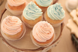 Wooden stand with tasty cupcakes on table, closeup