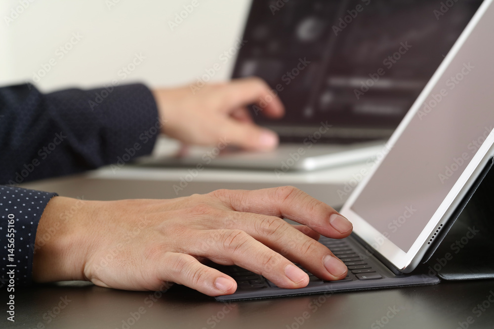 close up of businessman hand working with laptop and digital docking keyboard tablet computer in modern office close up of businessman hand working with laptop and digital docking keyboard tablet computer in modern office