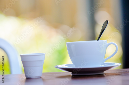 A spoon in cup of coffee on the table  blurry beautiful background