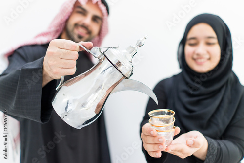 Gulf Arabian young couiple  with traditional coffee photo