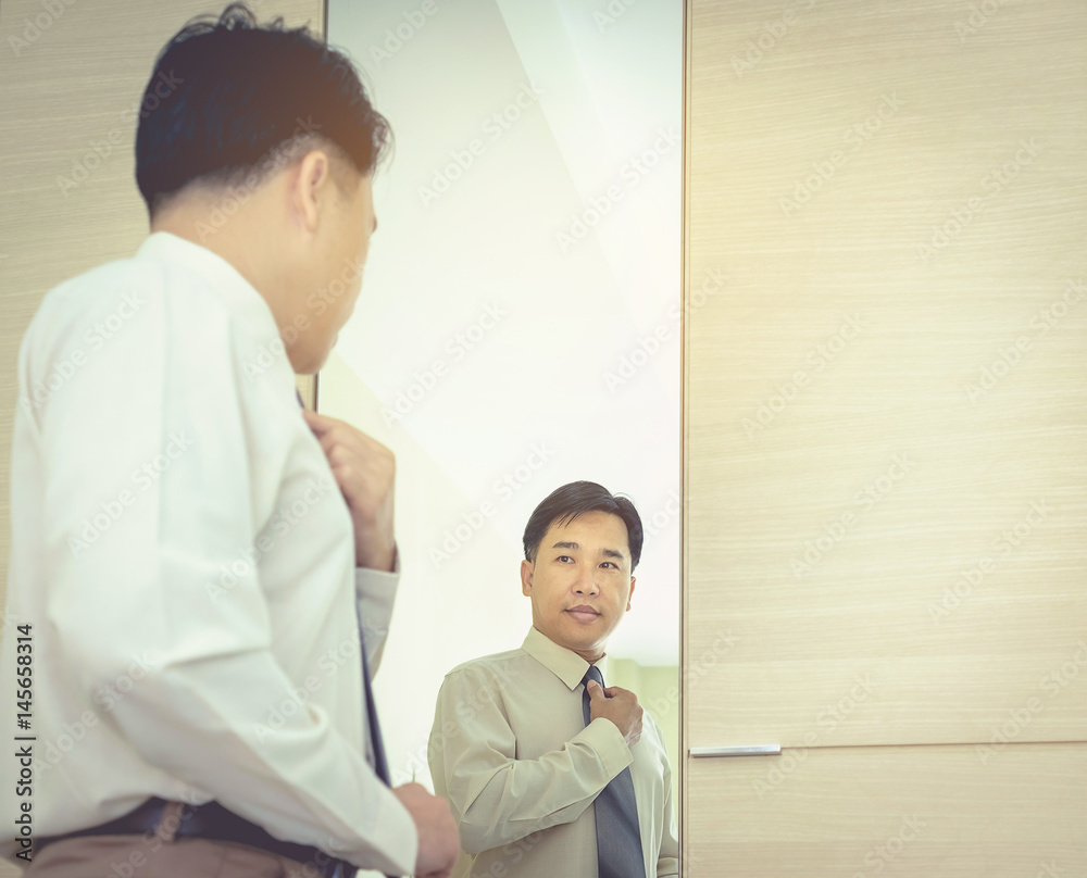Business men are shining a mirror, dressing up a costume to work out. A daily routine Business men are shining a mirror, dressing up a costume to work out. A daily routine