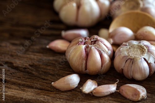 Close up garlic bulb in bowl on wooden table 