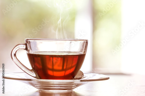 Zamyka w górę ciepłej czarnej herbacianej filiżanki na drewnianym stole w żywym pokoju, relaksuje z herbacianego czasu pojęciem