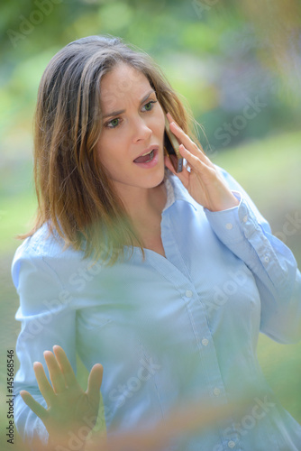 Angry woman outdoors on cellphone