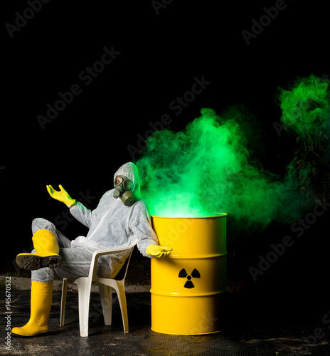 biohazard worker and radioactive green smoke coming out from yellow barrel