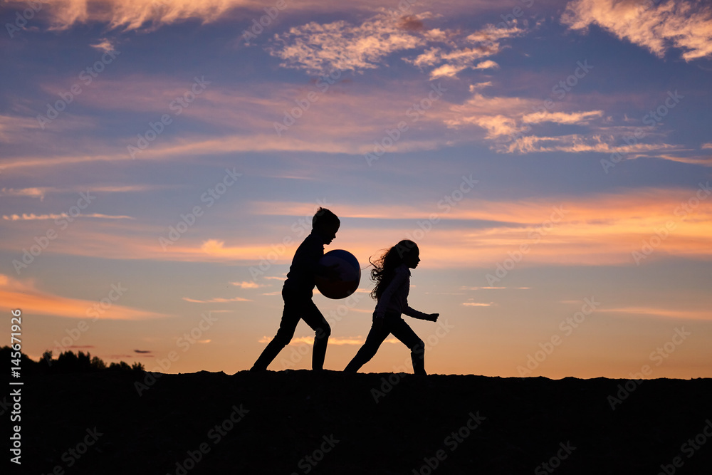 children running on the background of sunset sky
