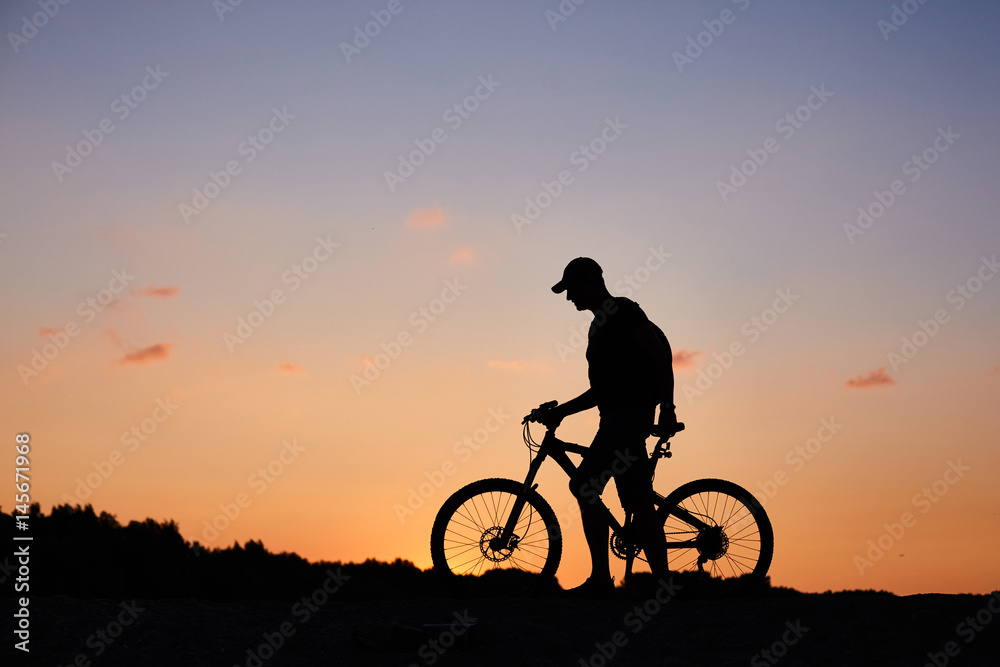 cyclist on the sunset sky background. silhouette of a man on a bicycle cyclist on the sunset sky background. silhouette of a man on a bicycle