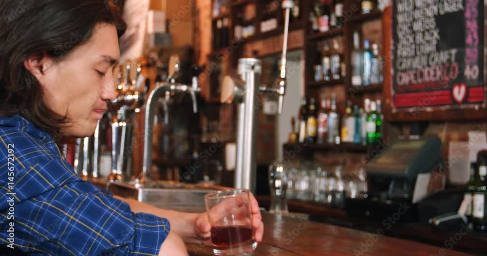 Depressed man having whisky at bar counter Depressed man having whisky at bar counter