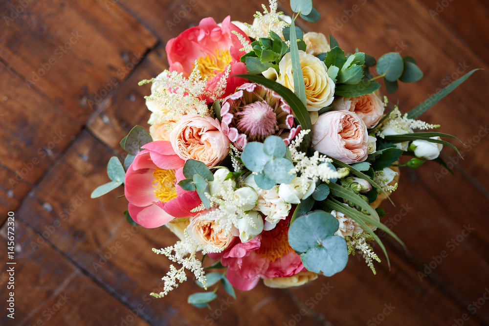 Obraz premium bridal bouquet with peonies and protea and boutonniere on the wooden floor