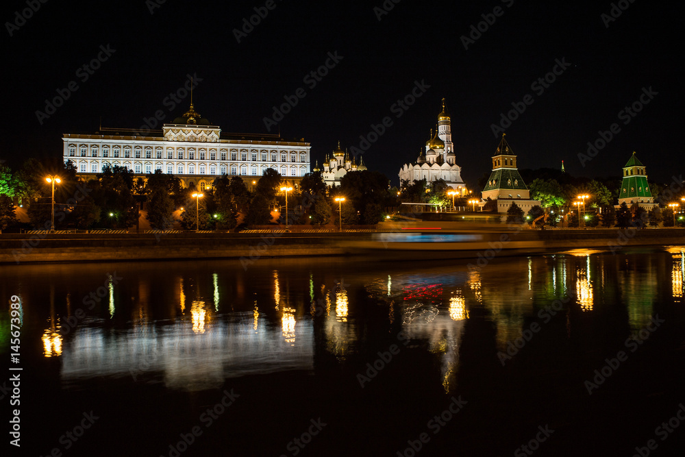Moscow, Russia - July, 17 2016: View of the Moscow Kremlin at night with reflection in the river and the shadow of the ship
