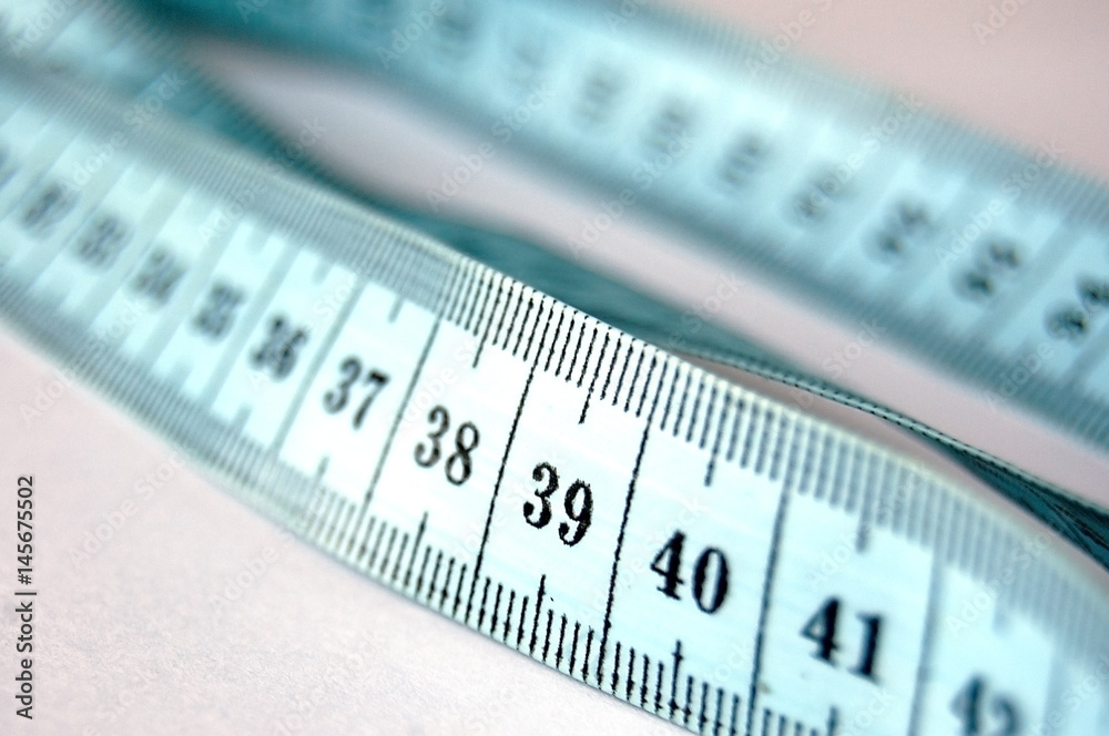 Measuring meter for tailor, meter for sewing on light background. Selective focus Measuring meter for tailor, meter for sewing on light background. Selective focus