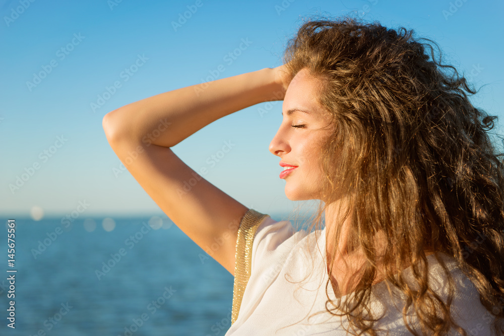 Young beautiful lady with long curly hair and closed eyes Young beautiful lady with long curly hair and closed eyes