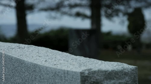 slow motion rose placed on top of grave stone in cemetary