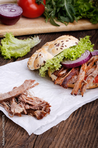 Pulled pork burger with coleslaw tomato, onion and fresh bread.