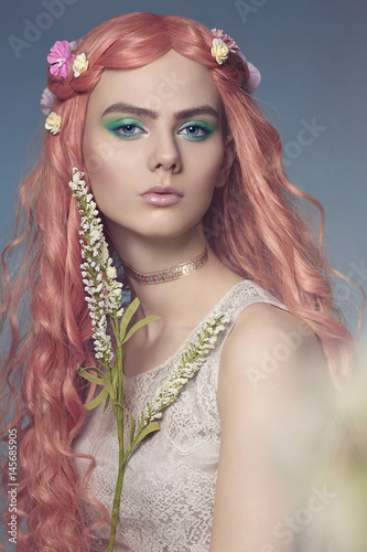 Beautiful young woman with pink hair and flowers photo