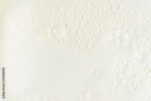 White milk or soy bubble foam background on top view close up