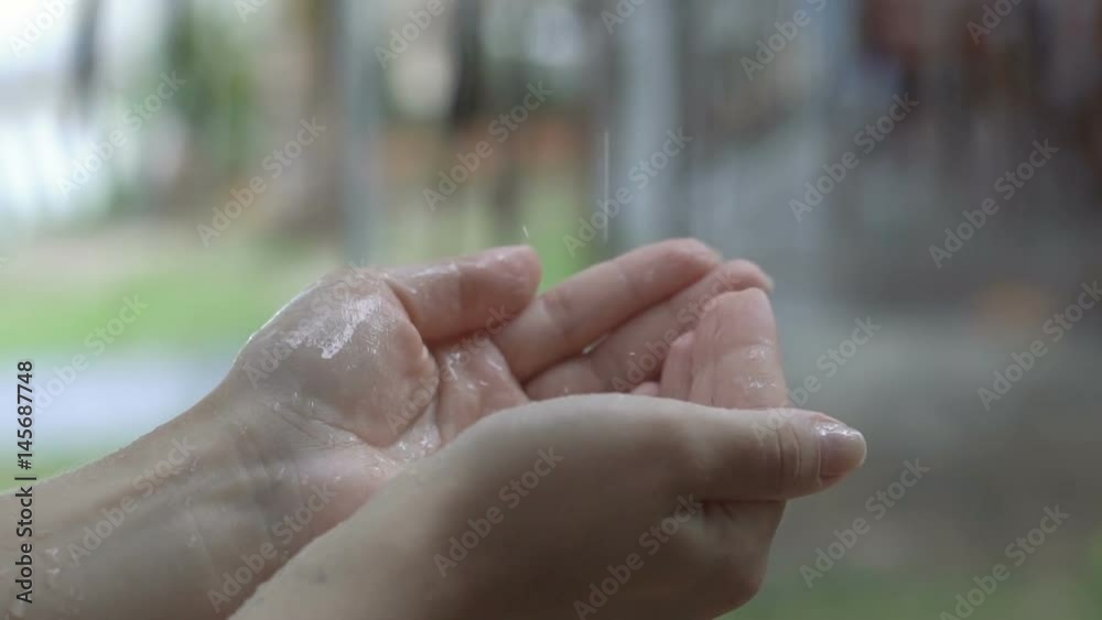 Water drops in hand. Rain water drops falls in a female hand in slow motion. Water drops in hand. Rain water drops falls in a female hand in slow motion.
