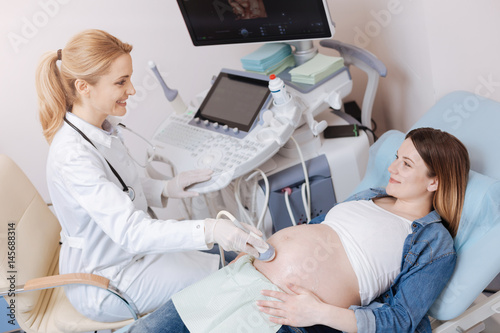 Young future mother getting ultrasonic abdomen examination in the hospital