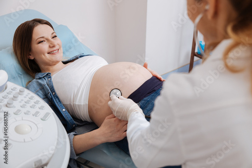 Positive woman getting pregnant belly examination in the hospital photo