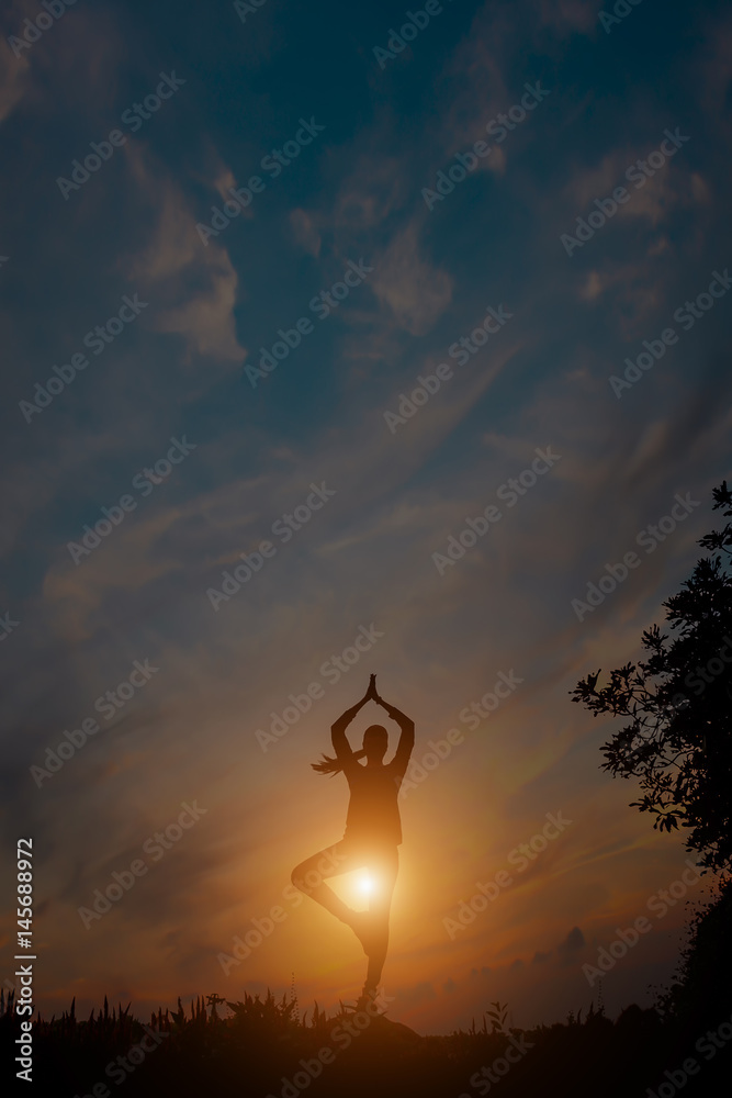 Silhouette of a yoga woman in sunset