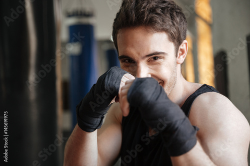 Close up view of smiling boxer doing exercise in gym