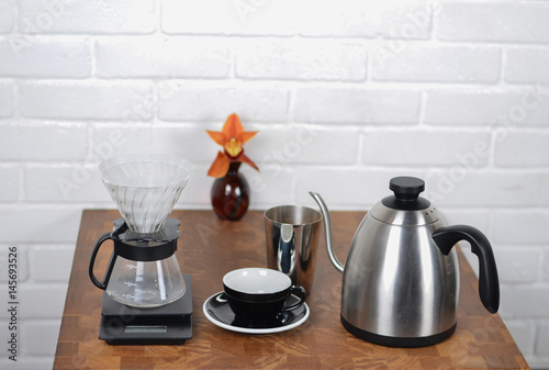 Coffee maker, kettle, coffee cup on the table photo