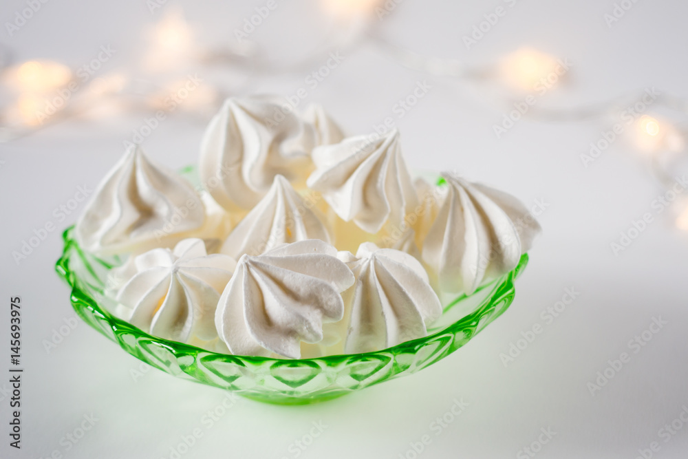 Meringue cookies on a green glass retro plate on white background Meringue cookies on a green glass retro plate on white background