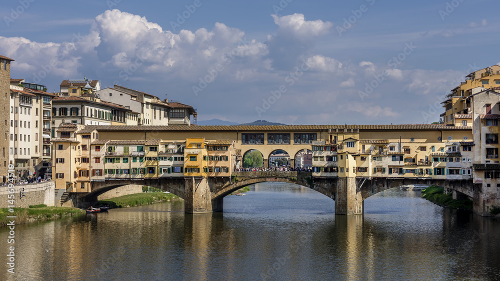 Superb view of the famous Ponte Vecchio bridge from Ponte Santa Trinita, against a picturesque sky, historic center of Florence, Italy