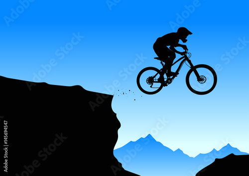 Silhouette of a biker jumping from mountain ledge