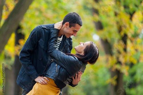 photo of cute couple hugging and smiling on the wonderful autumn park background