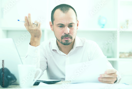 Confused young man at workplace photo