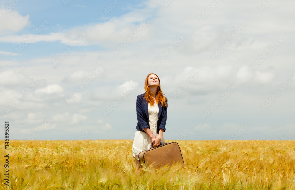 photo of beautiful young woman with suitcase on the wheat field background photo of beautiful young woman with suitcase on the wheat field background