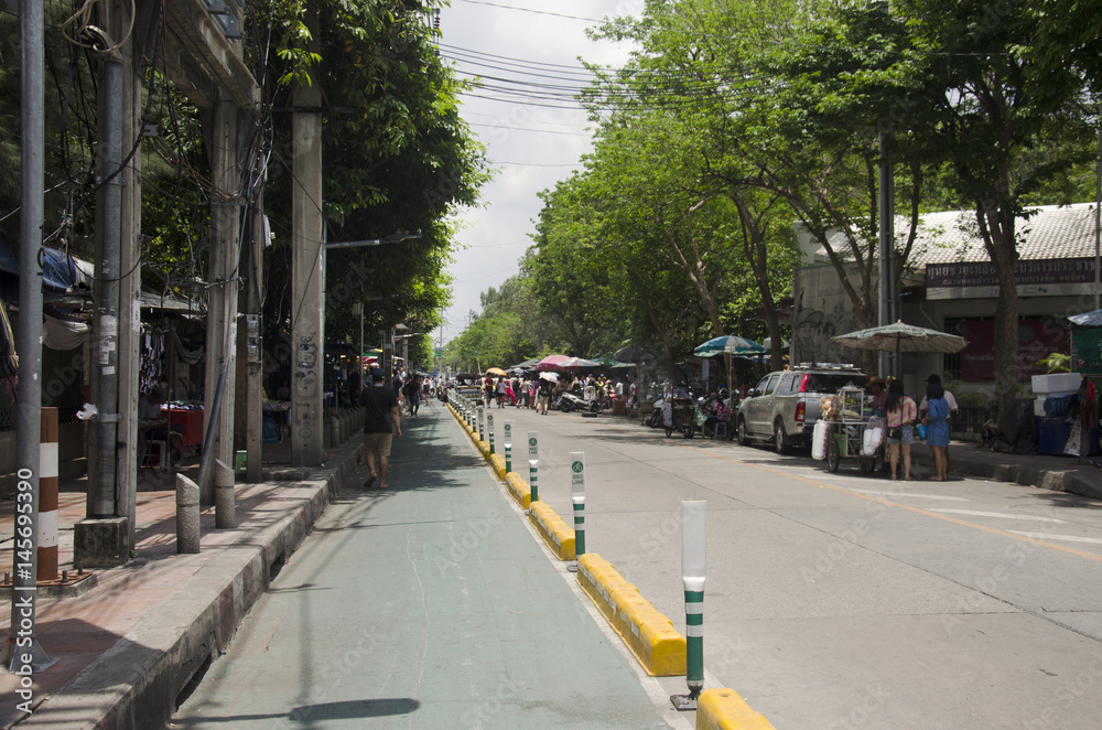Bicycle lane on the road with people walking and traffic at Chatuchak Market