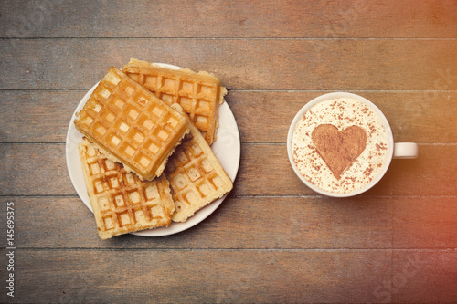 photo of plate full of waffles and cup of coffee on the wonderful brown wooden background