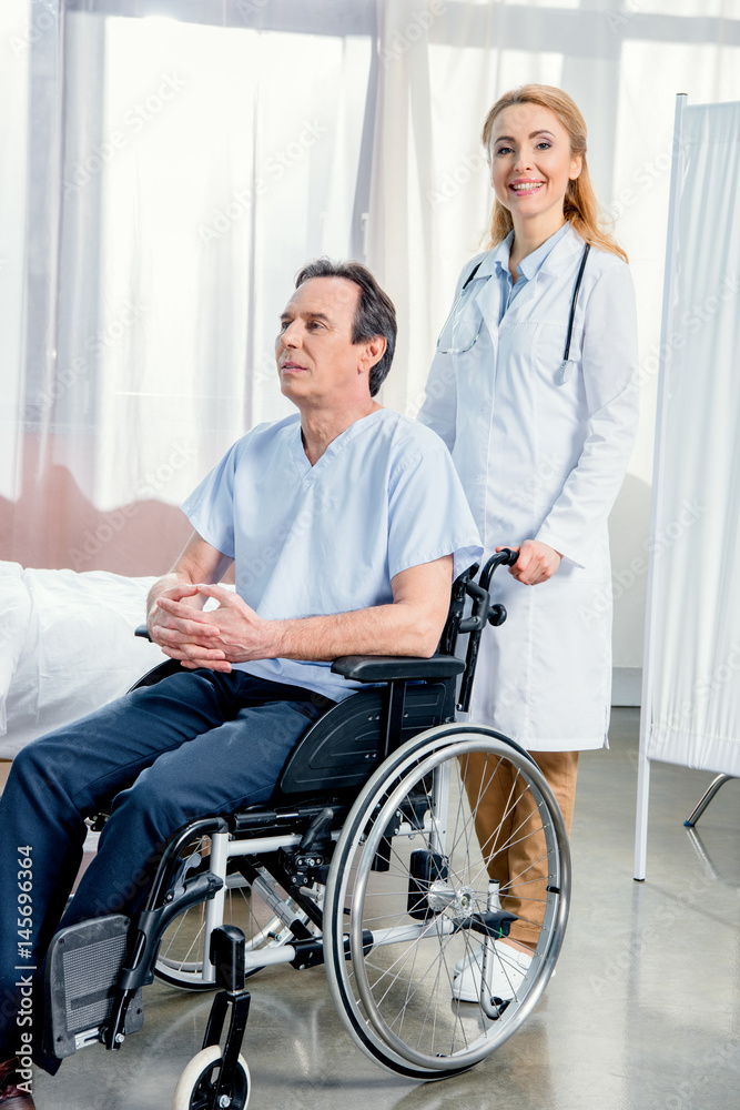 elderly man sitting in wheelchair and doctor standing near him in hospital elderly man sitting in wheelchair and doctor standing near him in hospital