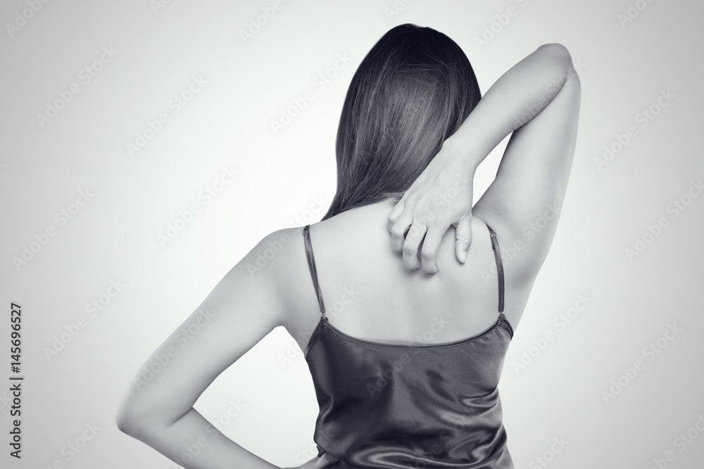 Obraz premium Woman scratching her itchy back with allergy rash, Concept with Healthcare And Medicine.