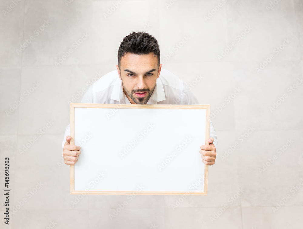 Young confident man with white board copy space for message or text image Young confident man with white board copy space for message or text image