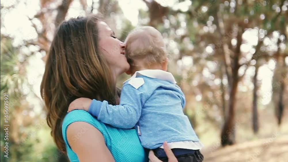 Son is sitting in his mother's arms and waving his hand Son is sitting in his mother's arms and waving his hand