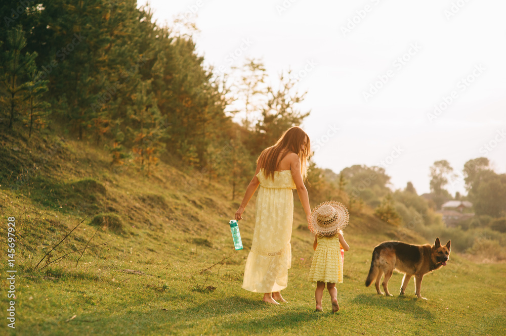mother walk with his little daughter, and their dog mother walk with his little daughter, and their dog