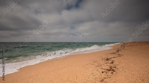 Crimea, sea surf on the beach coast of the Black Sea in cloudy weather.