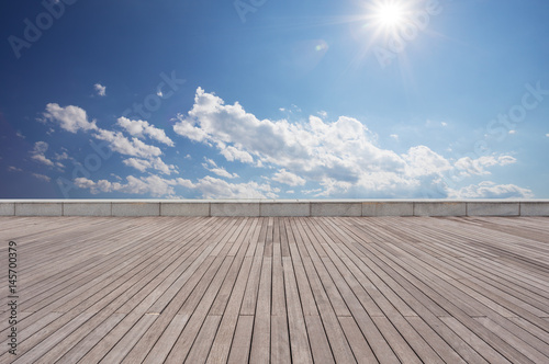 empty wooden floor with blue sunny sky