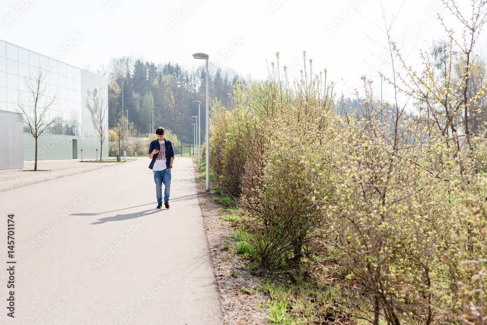 Junger Mann mit Handy auf Straße Junger Mann mit Handy auf Straße