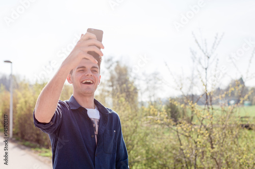 Junger Mann mit Handy auf Straße