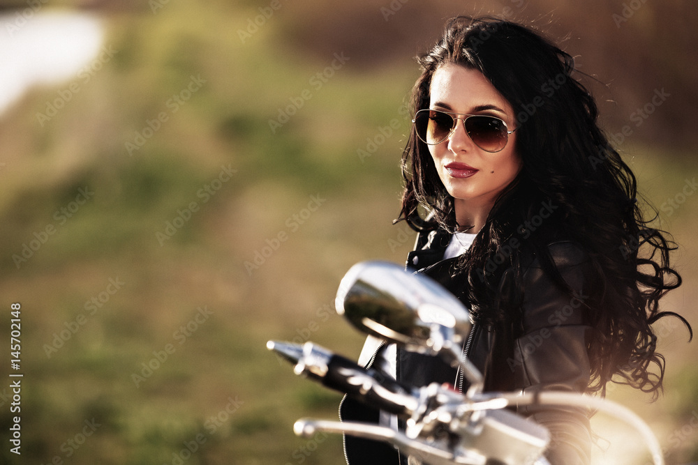 Obraz premium Beautiful brunette woman with a classic motorcycle (cinema bleach bypass effect)